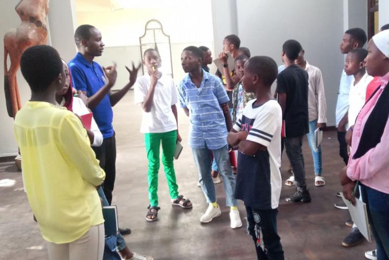 De kinderen luisteren aandachtig naar de gids die onze groep meenam door het museum.